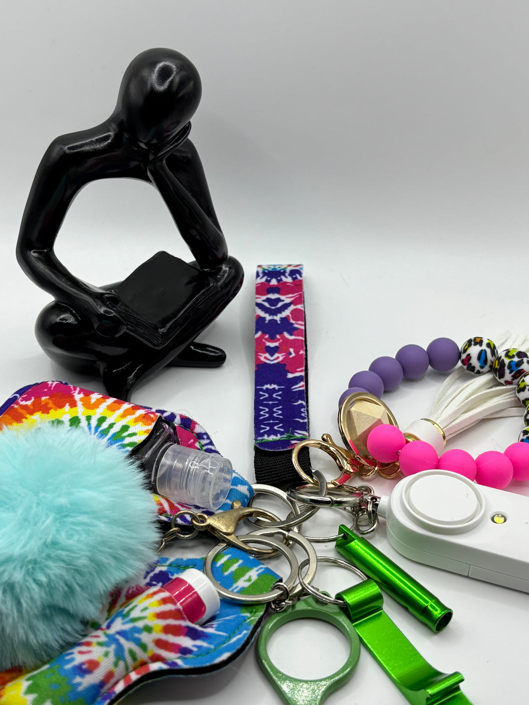 9 colorful acrylic affirmation keychains arranged in a row, each with a motivational word like Joy, Strength, or Power. Handmade by youth entrepreneur Cai, perfect for gifting or personal use